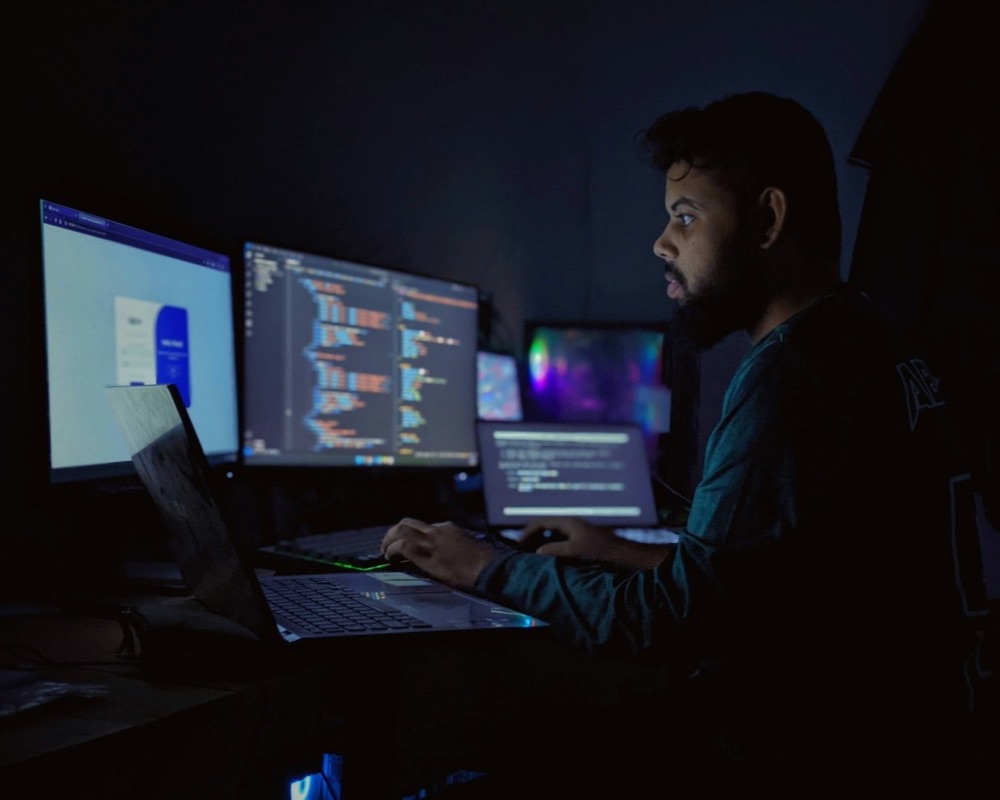 Engineer watching server dashboards on several screens