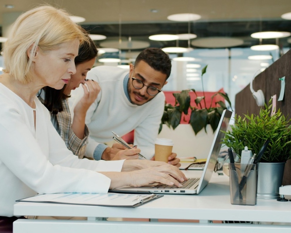Three colleagues working together on a laptop