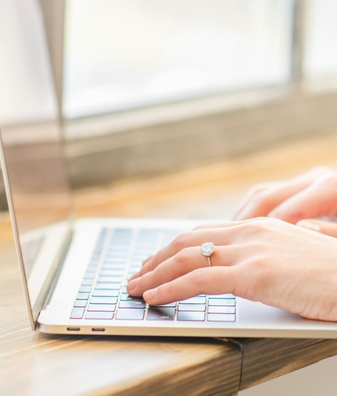 Hands typing on a laptop