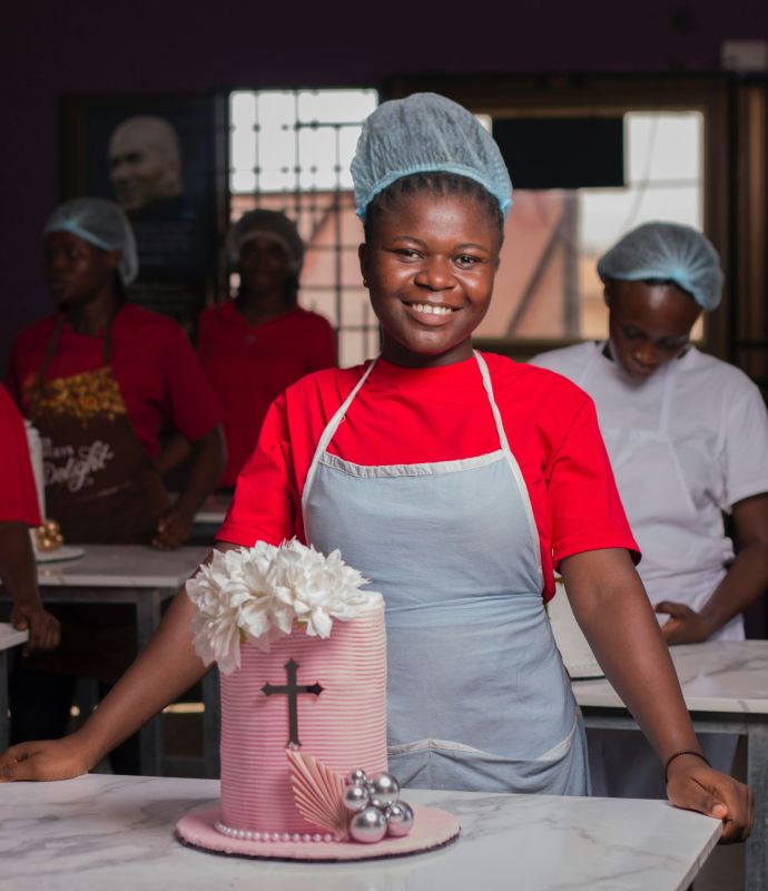 Smiling baker in her bakery next to a cake