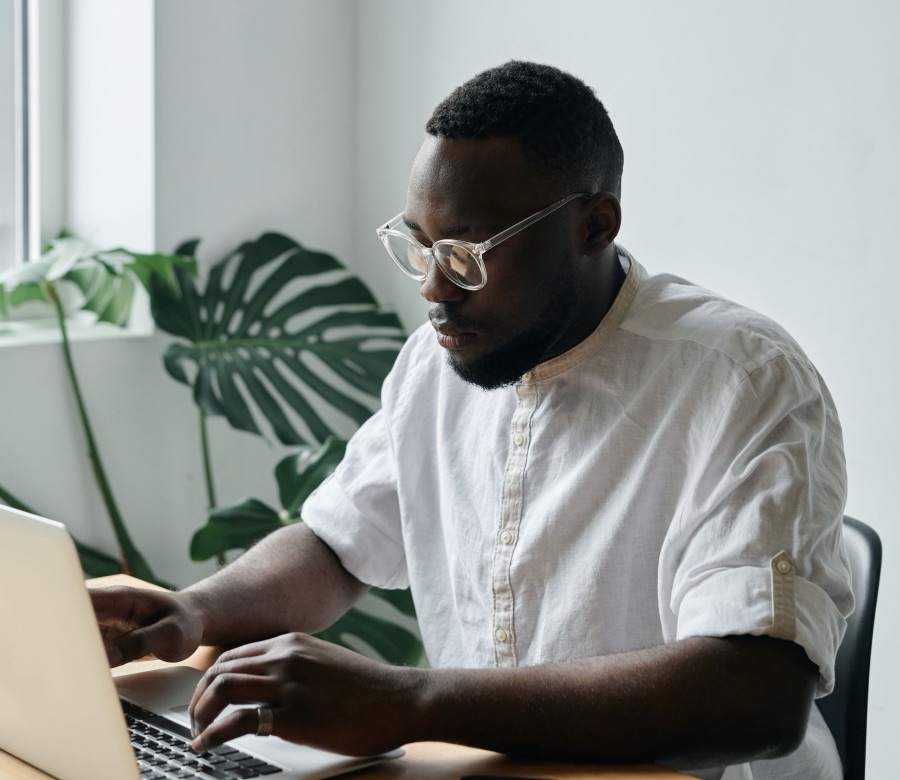Man working on a laptop at a bright desk