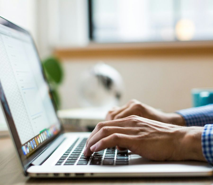 Hands typing on a laptop keyboard