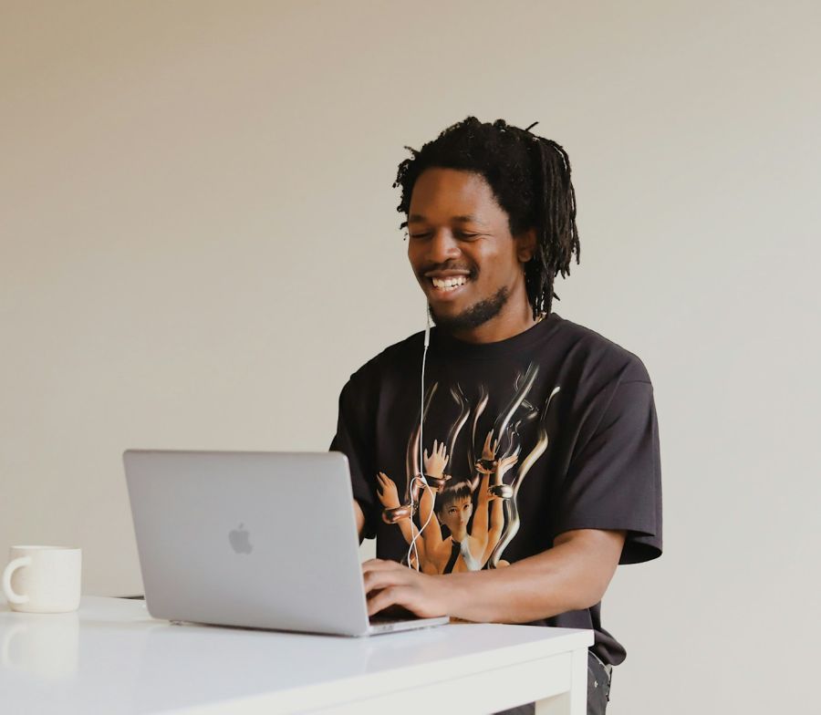 Smiling man working on a laptop at his desk